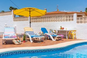a pool with chairs and a table with an umbrella at Villa Caseta de Sau - PlusHolidays in Calpe