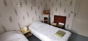 ein Schlafzimmer mit zwei Einzelbetten und einer Tür in der Unterkunft Villa indépendante, parc et piscine privée, ramassez vos oeufs coques in Saint-Médard-de-Guizières