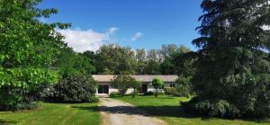 ein Haus mitten auf einem Feld mit Bäumen in der Unterkunft Villa indépendante, parc et piscine privée, ramassez vos oeufs coques in Saint-Médard-de-Guizières