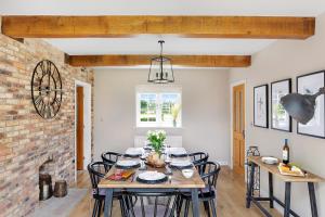 a dining room with a table and chairs and a brick wall at Ashley Cottage in York