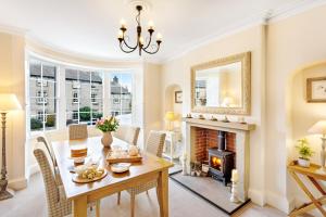 a dining room with a table and a fireplace at Milton House in Leyburn