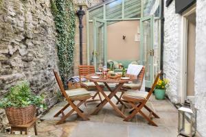 a patio with a wooden table and chairs at Milton House in Leyburn