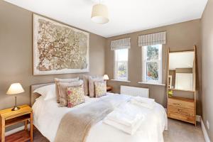 a bedroom with a large white bed and two windows at Thorncliffe House in York