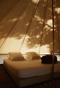 - un lit dans une chambre avec voile sur un bateau dans l'établissement Village Del Mar - Corse, à Solaro