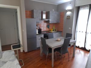 cocina con mesa y sillas en una habitación en Elegant and modern Apartment "Le Fontane" Moncalieri, en Moncalieri