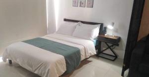 巴科洛德的住宿－Condo with direct access to shopping mall in Bacolod City，卧室配有一张床,床头柜位于床边。
