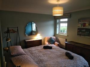 a bedroom with a large bed and a mirror at The Whimsy 2 bedroom cottage in National Forest, private parking & garden in Blackfordby