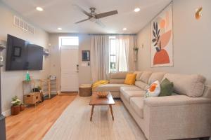 uma sala de estar com um sofá e uma televisão de ecrã plano em Beautiful Home w/ Rooftop Deck Within A 5 Mintue Walk To Johns Hopkins Hospital em Baltimore