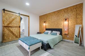 a bedroom with a bed and a sliding barn door at Castanheiro's Place in Ponta Delgada