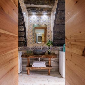 a bathroom with a wooden table and a mirror at Castanheiro's Place in Ponta Delgada