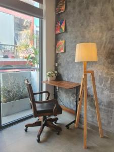 a desk with a chair and a lamp next to a window at ZVillage NCC - Modern Townhouse in District 1 in Ho Chi Minh City