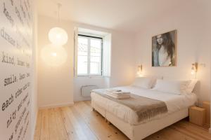 ein weißes Schlafzimmer mit einem Bett und einem Bild an der Wand in der Unterkunft MY LX FLAT Castle Alfama Apartments in Lissabon