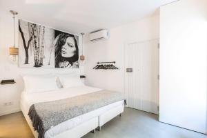リスボンにあるMY LX FLAT Castle Alfama Studioの白いベッドルーム(ベッド1台付)が備わります。壁には絵画が飾られています。