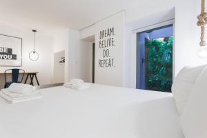 リスボンにあるMY LX FLAT Castle Alfama Studioの白いベッドルーム(ベッド1台、テーブル付)