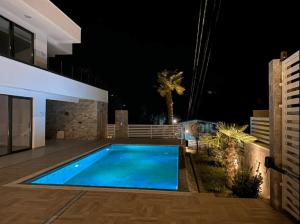 a swimming pool in the backyard of a house at night at Villa Elia in Utjeha