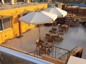 Tamara Pyramids Inn في القاهرة: فناء في الهواء الطلق مع طاولات وكراسي ومظلات