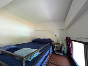 Schlafzimmer mit einem Bett mit blauer Bettwäsche und einem Fenster in der Unterkunft Studio B Loft M&K's Guesthouse in Dauis