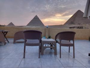 due sedie e un tavolo con vista sulle piramidi di Tamara Pyramids Inn a Il Cairo