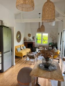 a kitchen and living room with a table and chairs at Villa Athena Cap-Ferret chez l habitant in Lège-Cap-Ferret