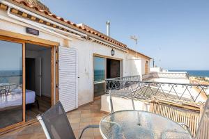 a patio with a glass table and chairs on a balcony at Amazing Sea Views Santa Pola AC in Santa Pola
