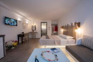 a bedroom with two beds and a living room at Myrsini's Luxury Suites Merchia in Mýkonos City