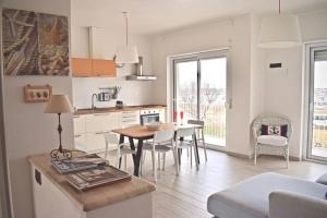 a kitchen and living room with a table and chairs at Harbor Houses II in Marzamemi