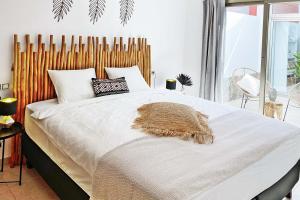 Un dormitorio con una cama grande con cabecero de madera. en Caleta Blanca, en La Guirra 12 fotos más