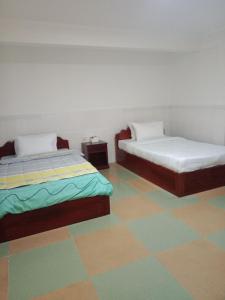two beds in a room with a colorful floor at Centro Guest House in Siem Reap