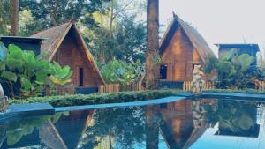 una casa con un reflejo en una piscina de agua en Triangle House and hot spring, en Kintamani