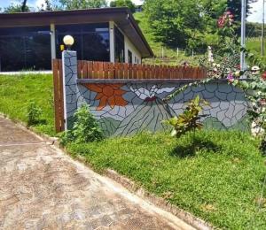 a retaining wall with a flower mosaic on it at Amazing Villa at Lake Arenal 1 in Tronadora
