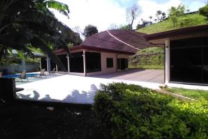 una casa con techo morado y patio en Amazing Villa at Lake Arenal 1 en Tronadora