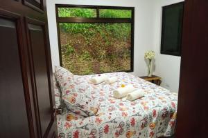 a bed with towels on it with a window at Amazing Villa at Lake Arenal 1 in Tronadora