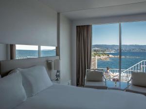 a hotel room with a bed and a view of the ocean at Sofitel Golfe d'Ajaccio Thalassa Sea & Spa in Ajaccio