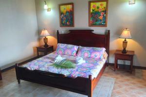 a bed in a room with two lamps on two tables at Palacial Villa at Lake Arenal in Tilarán