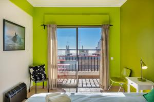 クアルテイラにあるVita Portucale ! Quarteira Sea Viewの緑豊かなベッドルーム(ベッド1台、バルコニー付)