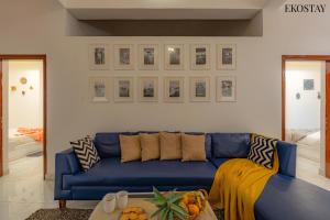 um sofá azul numa sala de estar com uma mesa em EKO STAY- CASA VAGA em Vagator