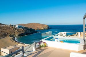 a balcony with a swimming pool next to the ocean at Myrsini's Luxury Suites Merchia in Mikonos