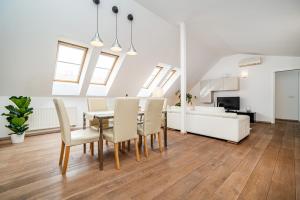 Large and stylish apartment in Prague في براغ: غرفة طعام وغرفة معيشة مع طاولة وكراسي
