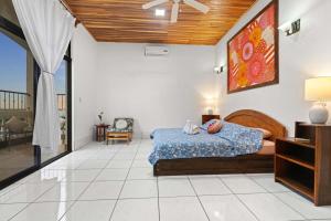 a bedroom with a bed with a blue comforter at Amazing PenthouseL 5 min from Coco Beach in Coco