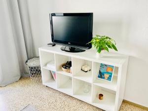 einen Fernseher auf einem weißen Stand mit einer Anlage in der Unterkunft Precioso Apartamento de vacaciones playa Valencia Pinedo 2024 in Valencia