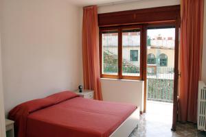 a bedroom with a red bed and a large window at Residence Le Villette in Ravello