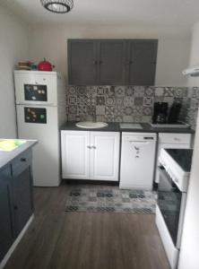 a kitchen with white cabinets and a white refrigerator at Vielle Aure Le 2 Bers 90m2 in Vielle-Aure