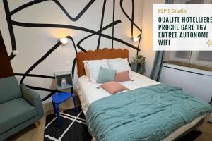 ein Schlafzimmer mit einem Bett, einem Stuhl und einer Wand in der Unterkunft PEP'S studio tout neuf au centre ville in Sélestat