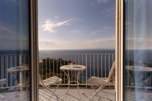 a balcony with a table and chairs and a view of the ocean at Hotel Villa Lubrense Sorrento in Massa Lubrense