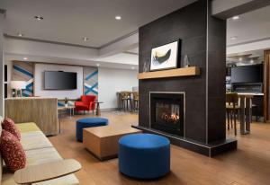 a living room with a fireplace and furniture at Hilton Garden Inn Boston-Burlington in Burlington