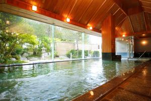 an indoor swimming pool with water in a building at Hida Takayama Onsen Takayama Green Hotel in Takayama