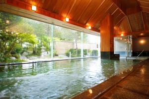 an indoor swimming pool with water in a building at Hida Takayama Onsen Takayama Green Hotel in Takayama