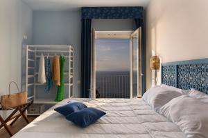 a bedroom with a bed with a view of the ocean at Hotel Villa Lubrense Sorrento in Massa Lubrense