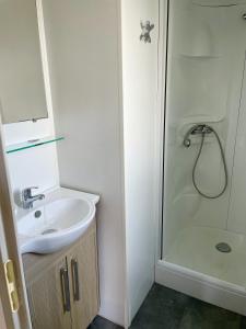 La salle de bains est pourvue d'un lavabo et d'une douche. dans l'établissement Tribord Dix Neuf, au Grau-du-Roi