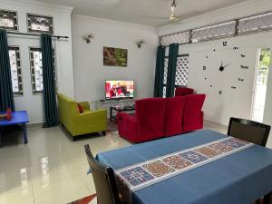 sala de estar con mesa, sillas y reloj en H Family Banglo Seremban #fit 20pax max #spacious carpark, en Seremban